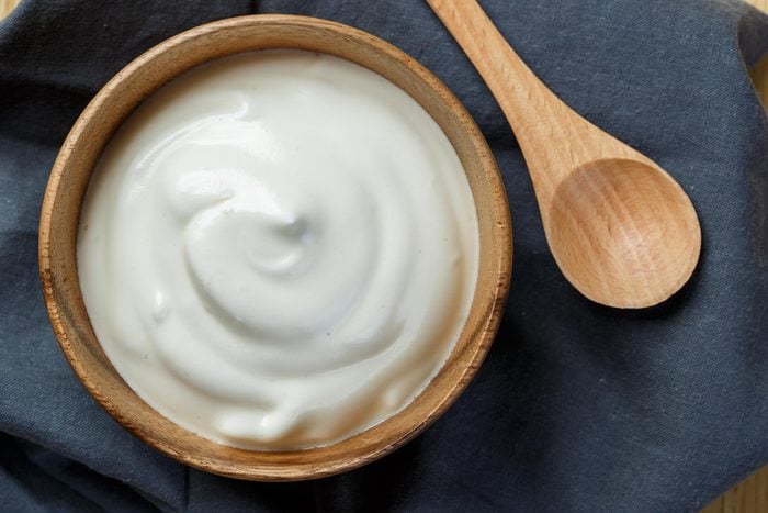 wooden bowl of yogurt with wooden spoon