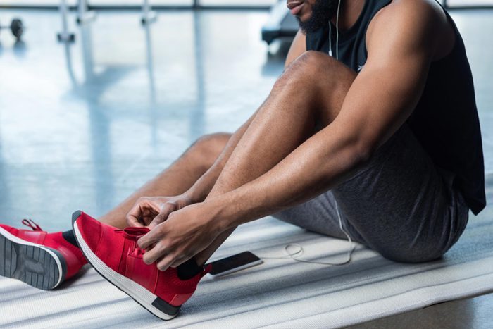 man lacing up sneakers before exercise