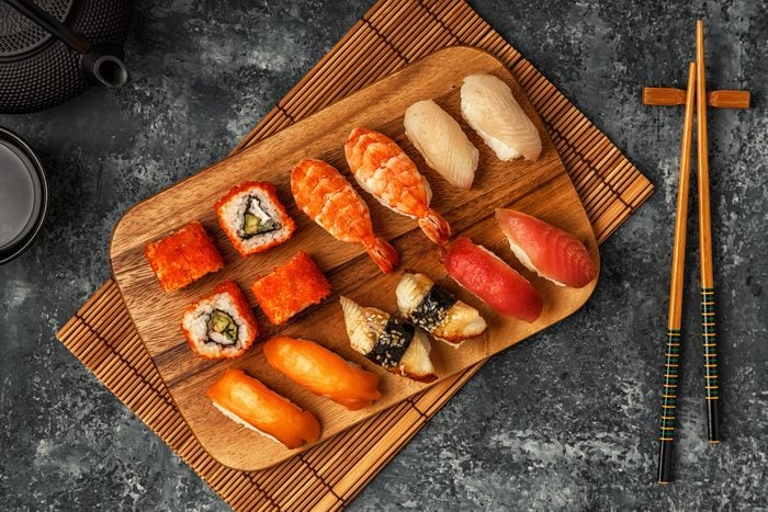 Sushi Set: sushi and sushi rolls on wooden plate, top view.