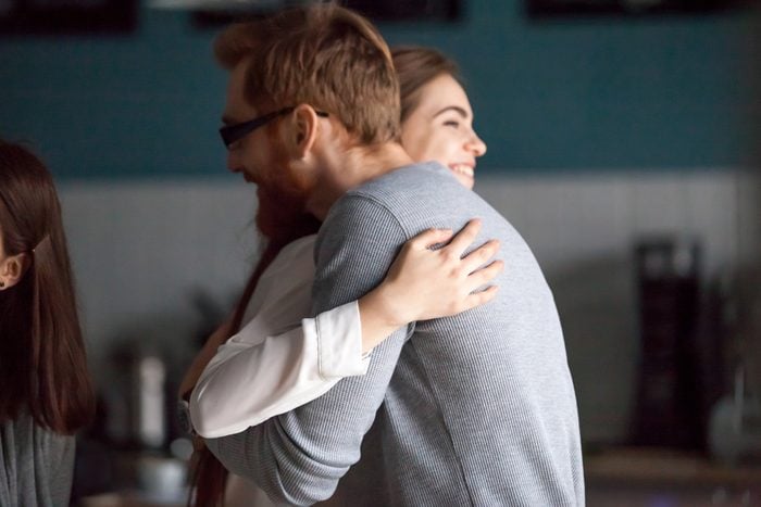 Friendly hug concept, smiling millennial man and woman embracing glad to see each other greeting at meeting, young guy and girl cuddling expressing care, friendship and good warm relations concept