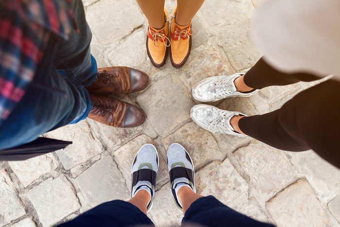 company of friends wearing different shoes, view from above, sneakers, boots, autumn fashion trend, close up legs, details, men and women standing together