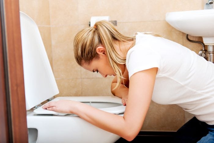 woman over toilet nausea
