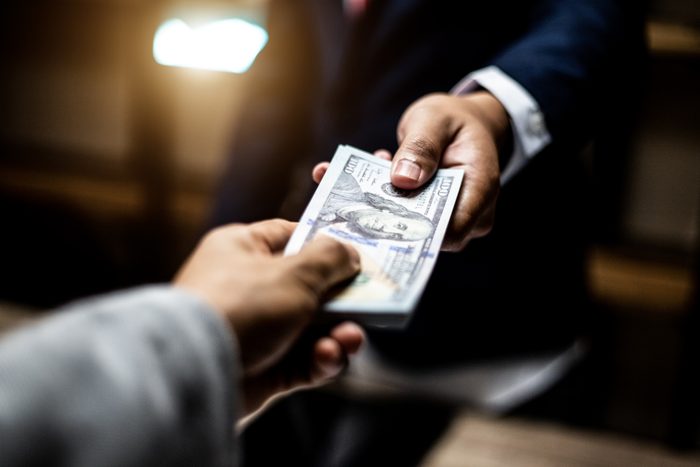 handing money to businessman close up
