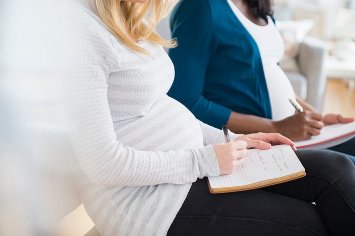 pregnant woman taking notes in prenatal class