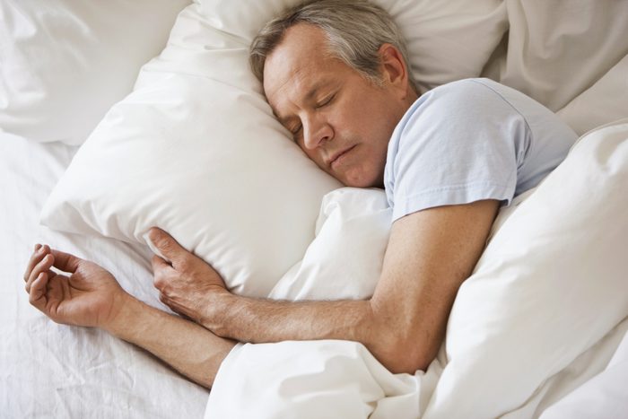 older man sleeping in bed