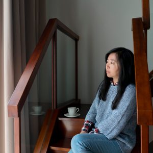 woman sitting at home looking out the window