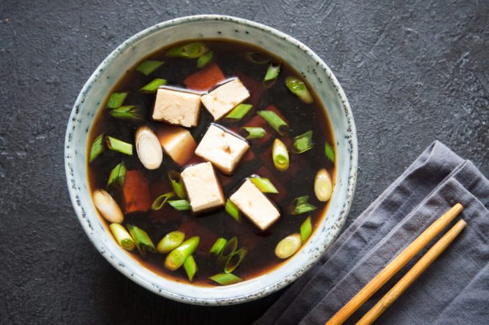 Japanese miso soup in ceramic bowl with tofu and green onions.