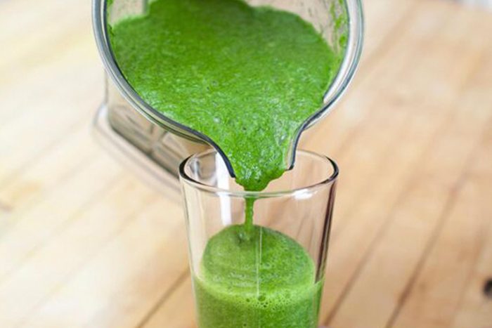 green smoothie pouring into glass
