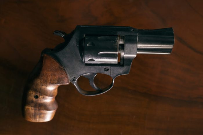 Revolver handgun over wooden background.