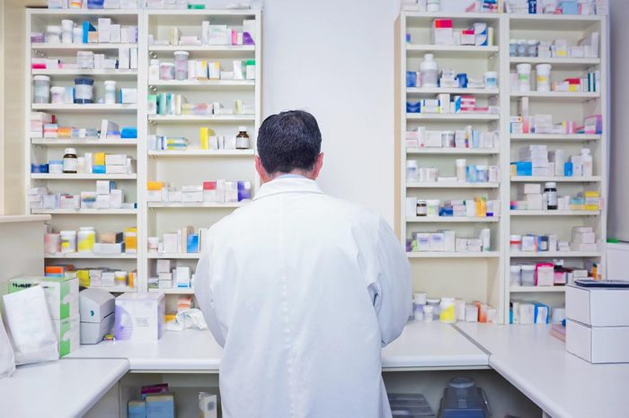 Rear view of a pharmacist working in lab coats in the pharmacy