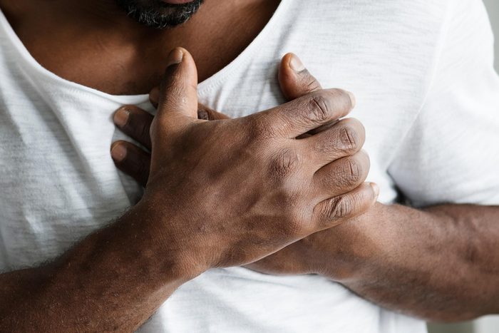 man with hands on heart; chest pain