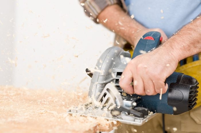 Home improvement - handyman cut wood with jigsaw in workshop