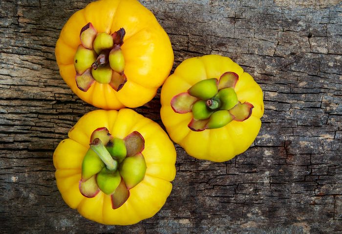 Top view. Three garcinia cambogia fruit on wood background and free form copy space. Garcinia atroviridis is a spice plants and hydroxy citric acids (HCA) for good health.