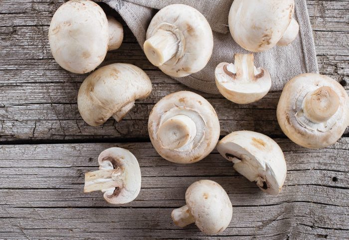 Fresh mushrooms champignons on a wooden background. Autumn Harvest Food Vegetarian Vegetable. Top View, Copy Space