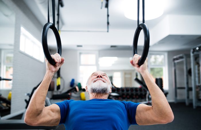 Man in gym working out on gymnastic rings