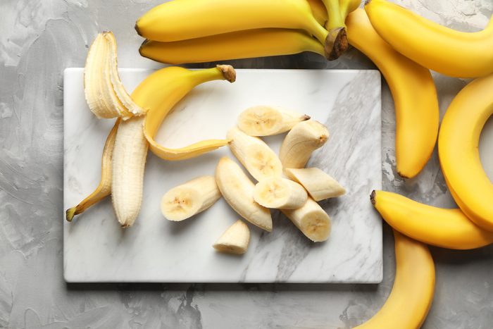 Marble board with sliced bananas on table