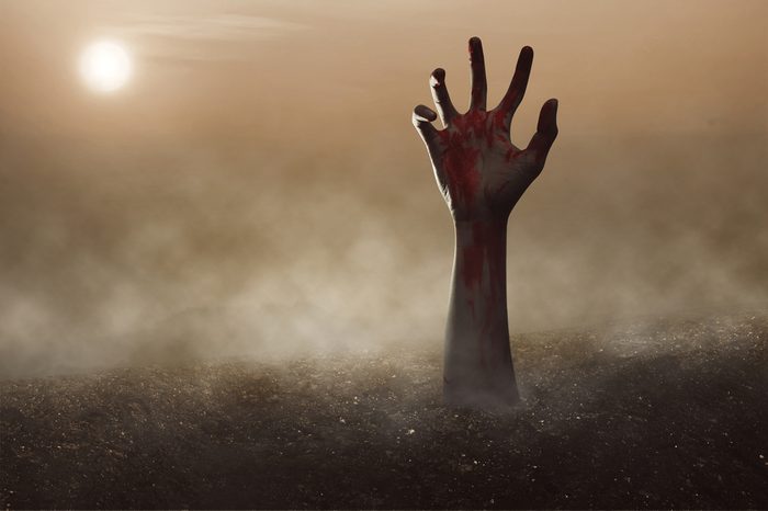 Zombie hand reaching out of the ground