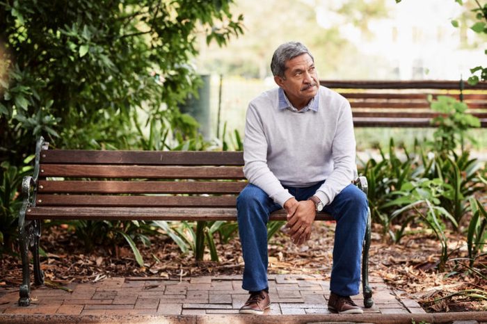 older man sitting on park bench
