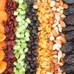 Dried fruit background. Rows of dried dates, apricots,cranberries, pomelos, blueberries, nuts, prunes and figs.