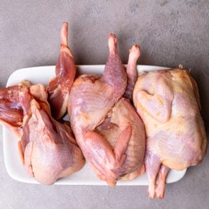 Fresh quails meat prepared to baking on grey background