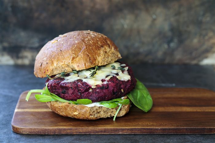 Vegetarian beetroot and black beans burger with melted cheese and thyme 