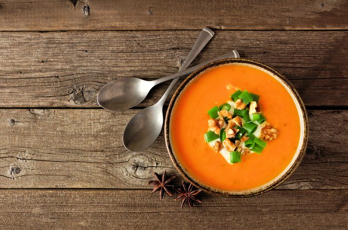 Creamy pumpkin soup. Autumn food concept. Top view on a rustic wood background.