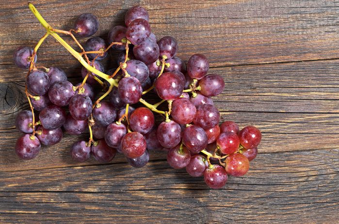 Red grapes on old wooden table
