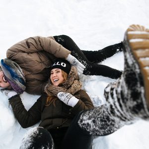 Winter. Cheerful young couple having fun in the snow. Winter love story.