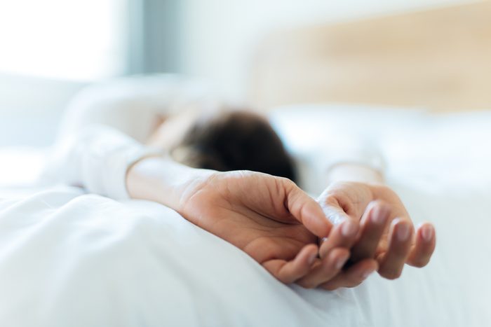 woman taking a nap on bed close up of hands