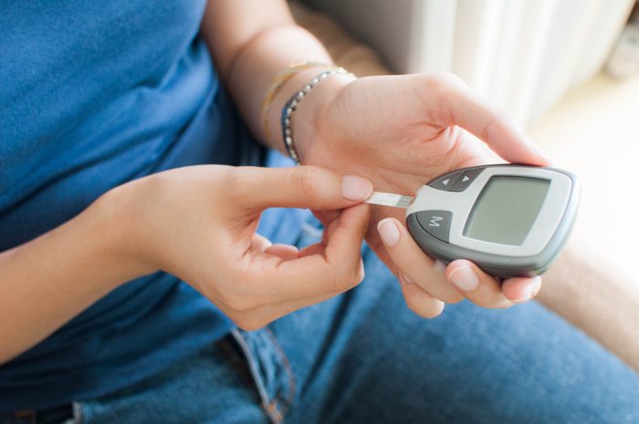 young woman using a glucometer for diabetes