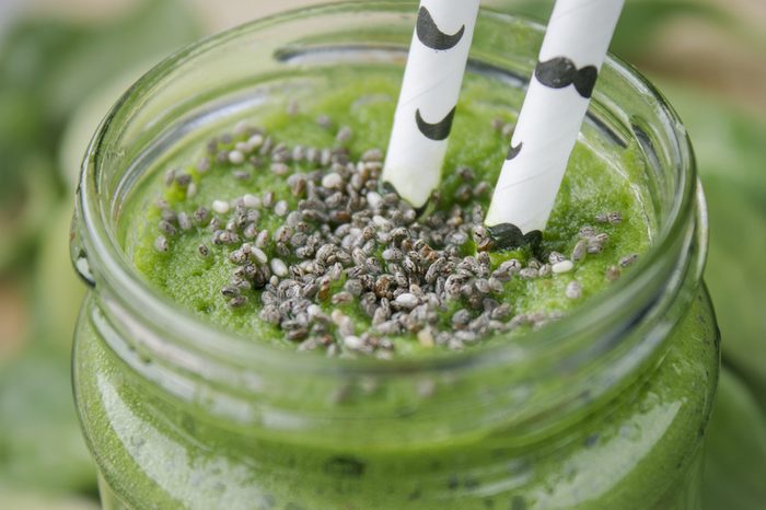 mason jar with green smoothie topped with chia seeds