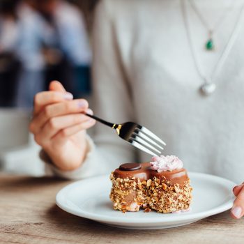 Closeup of woman eating chocolate cake in a cafe