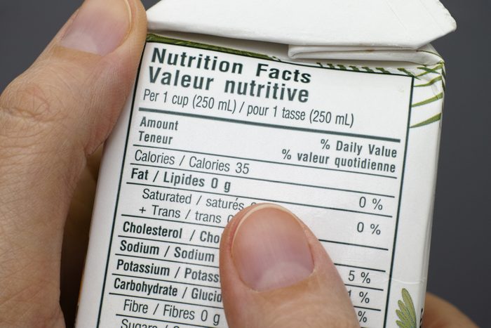Reading a nutrition facts on box with coconut water. 