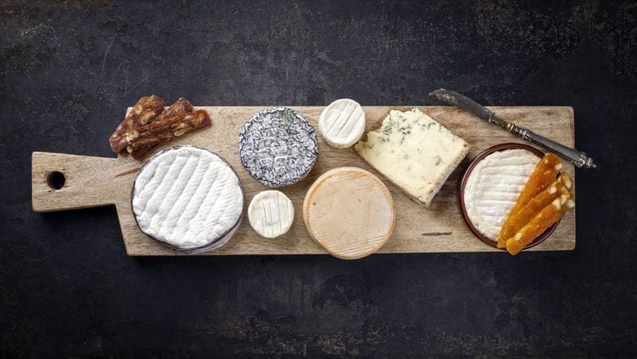 French Cheese Platter with Spanish Dulce de Membrillo as top view on a wooden board