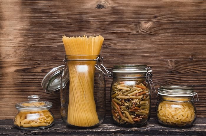 Pasta macaroni concept background. Pasta in a glass jar container.
