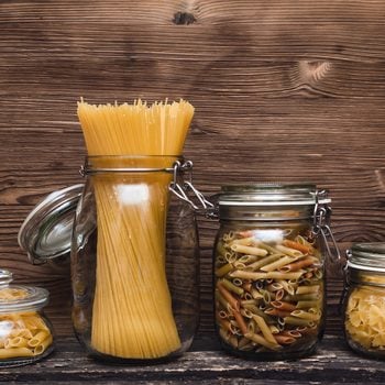 Pasta macaroni concept background. Pasta in a glass jar container.