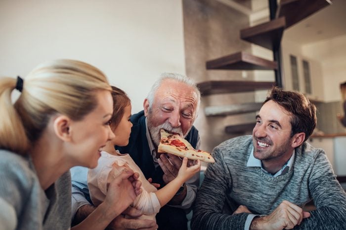 Three generation family having pizza together