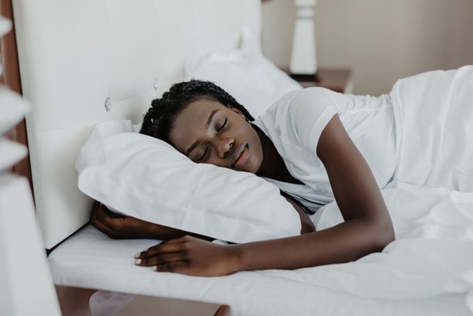 Attractive young african-american woman wakes up in her bedroom
