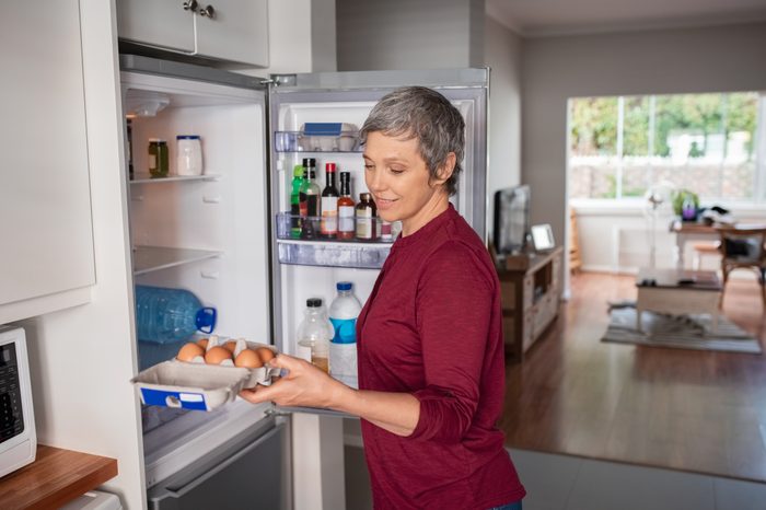 woman looking for food in refrigerator