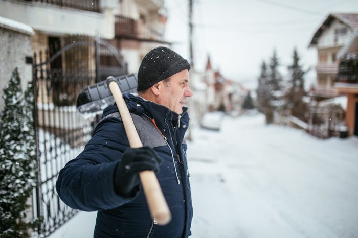 man prepared to shovel snow in winter