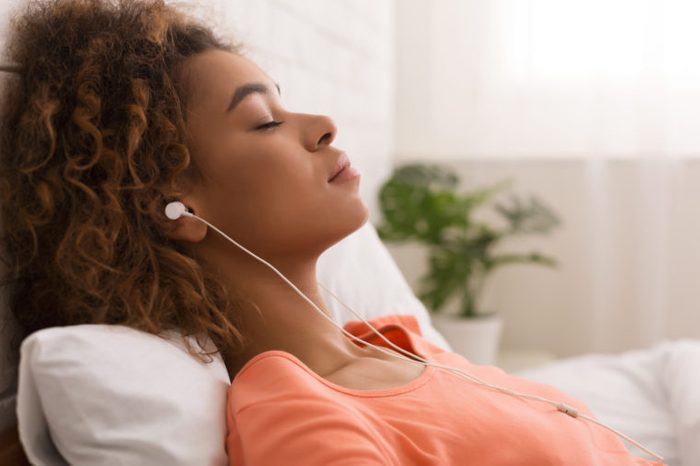 woman listening to calming music in bed
