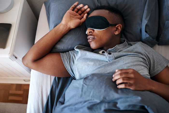 man sleeping in bed with eye mask on