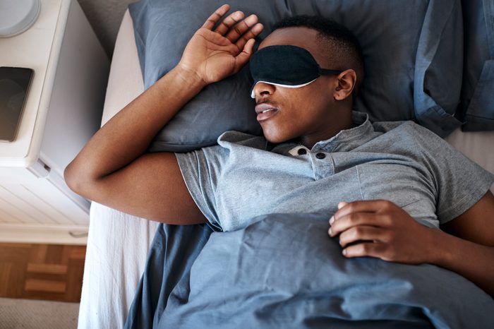 young man sleeping with sleeping mask over eyes
