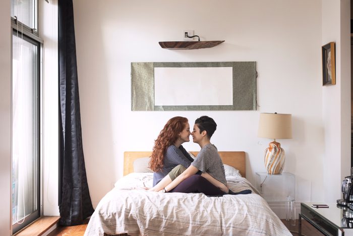 side view of romantic couple sitting in bed together