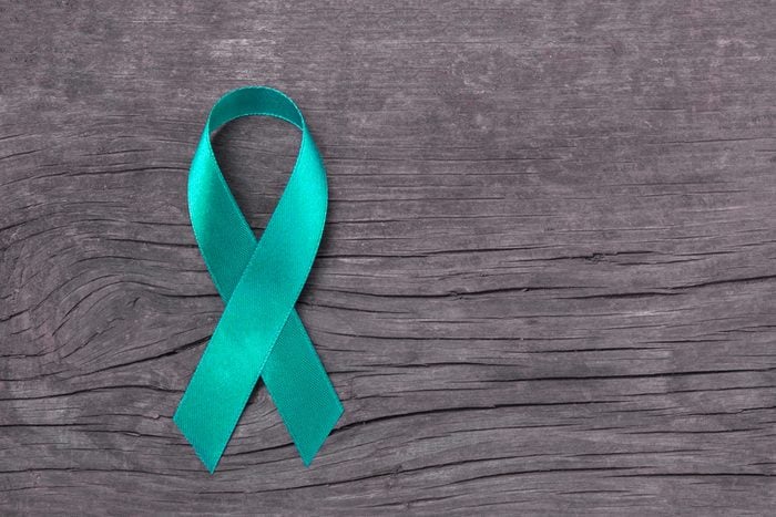 Teal ribbon awareness on woman's hand for Ovarian Cancer, Polycystic Ovary Syndrome (PCOS) disease, Post Traumatic Stress Disorder (PTSD), Tourette's Syndrome, Obsessive Compulsive Disorder (OCD)