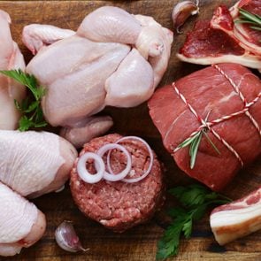 raw meat assortment - beef, lamb, chicken on a wooden board