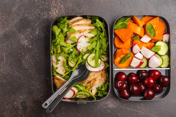 Healthy meal prep containers with grilled chicken with salad, sweet potato, berries, fruits and vegetables. Takeaway food.