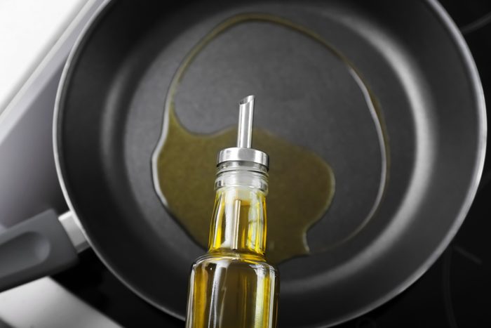 Pouring olive oil onto frying pan