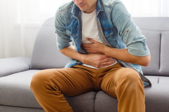 man holding stomach abdominal pain