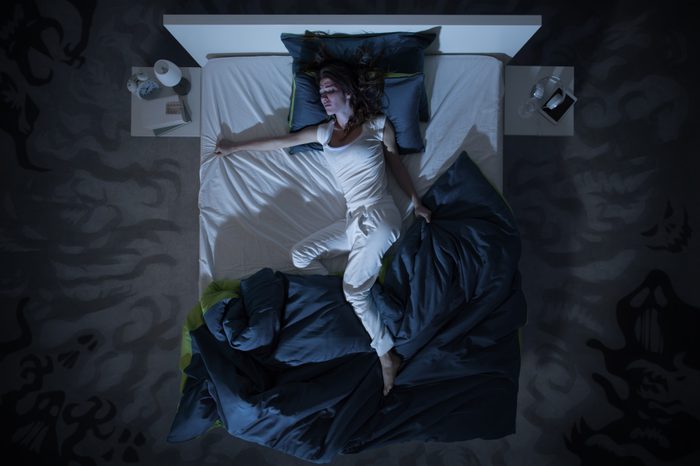 woman in bed at night trouble sleeping sweats